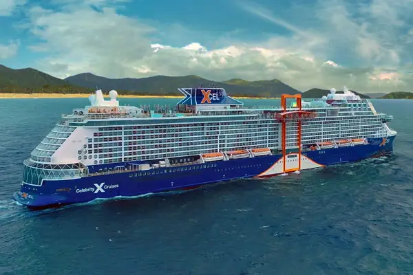 Celebrity Xcel cruise ship sailing near a tropical coast