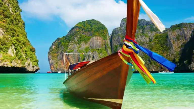 Longtail boat on turquoise water among limestone islands, Thailand