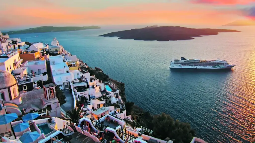 Cruise ship off Santorini's clifftop villages at sunset