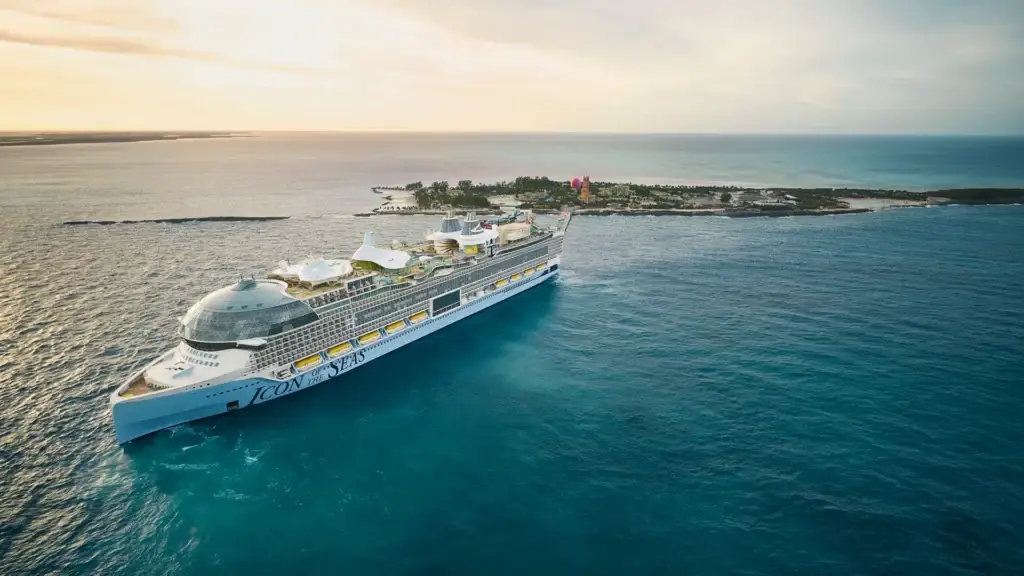 Royal Caribbean cruise ship sailing near a tropical island