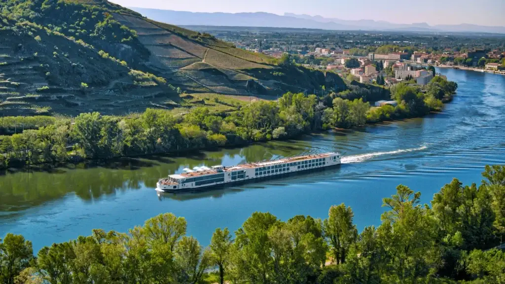 River cruise ship sailing through a green river valley
