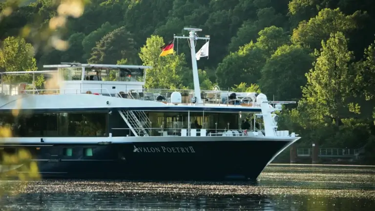 Avalon Waterways river ship docked along a tree-lined riverbank
