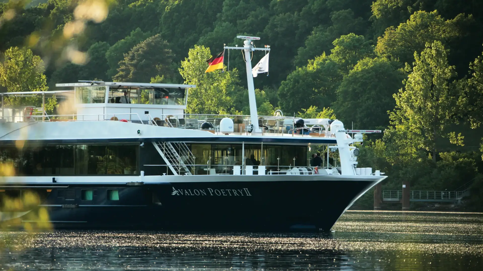 Avalon Waterways river ship docked along a tree-lined riverbank