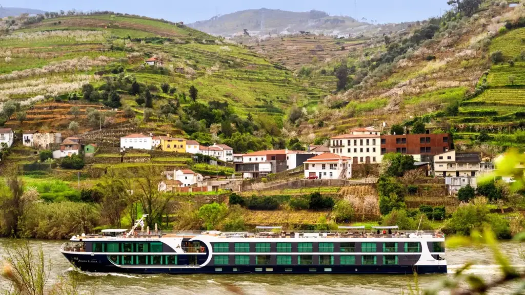 River cruise ship below terraced vineyards in Portugal's Douro Valley