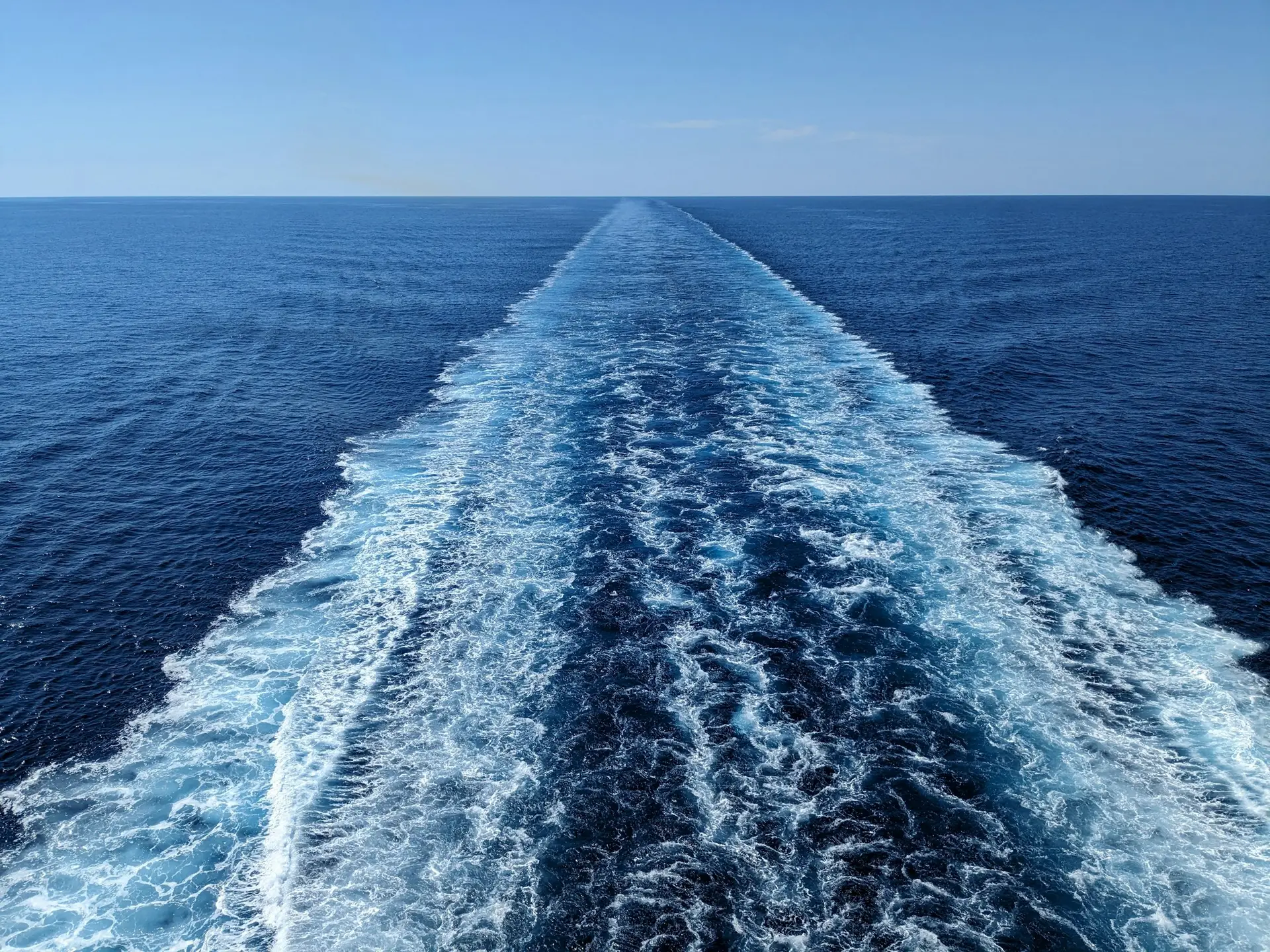 Wake trailing behind a ship on the deep blue ocean